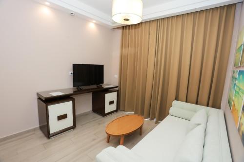 a living room with a couch and a tv and a table at Sole Luna Hotel in Borsh