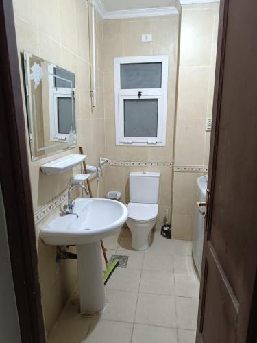 a bathroom with a sink and a toilet and a window at apartment b1 AL2 in Madinaty