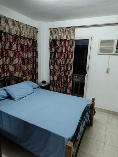 a bedroom with a bed with blue sheets and a window at apartment b1 AL2 in Madinaty