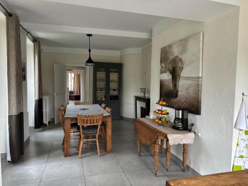 un salon avec une table et une salle à manger dans l'établissement Le Jardin Secret - Maison de location saisonnière, à Écos