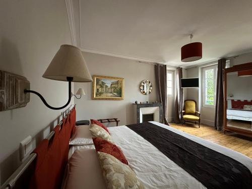 - une chambre avec un lit doté d'une lampe et d'une cheminée dans l'établissement Le Jardin Secret - Maison de location saisonnière, à Écos