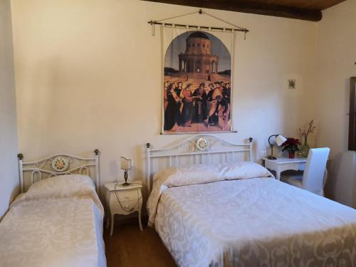 a bedroom with two beds and a painting on the wall at Il rifugio del duca in Solopaca