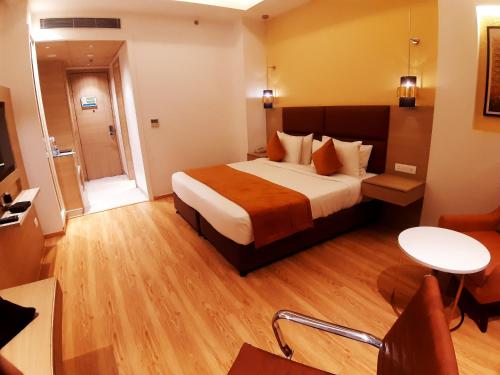 a hotel room with a bed and a table at Best Western Vrindavan in Vrindāvan