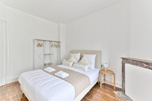 - une chambre blanche avec un grand lit et des draps blancs dans l'établissement Appartement à Montreuil cosy et confortable, à Montreuil
