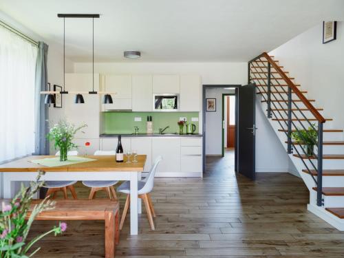 a kitchen and dining room with a table and a staircase at Farma Moulisových in Nezvěstice