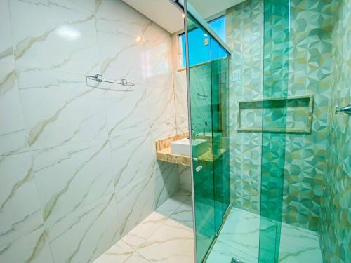 a bathroom with a glass shower and a sink at Ap 2 quartos espaçoso in Natal