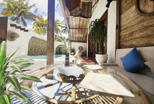a living room with a glass table and chairs at Kaleydo Villas in Gili Trawangan