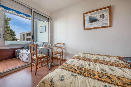 une chambre avec un lit, une table et une fenêtre dans l'établissement À 500m de la plage, appartement pour 4, à La Baule