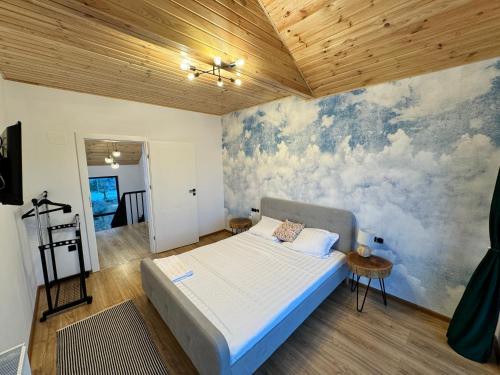 a bedroom with a bed and a painting on the wall at Cabana Brad Apuseni Villa in Cotorăşti