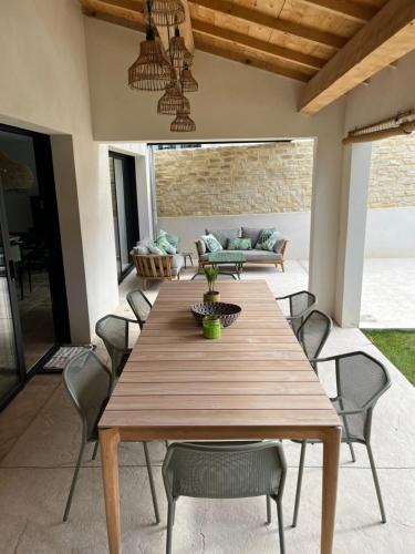 une table et des chaises en bois sur une terrasse dans l'établissement Villa Hélène, à Malaucène