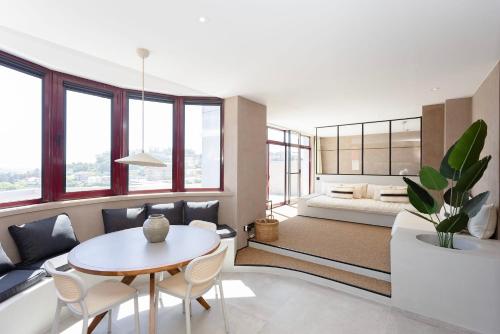 a living room with a table and a bed at Liiiving in Gaia - Panoramic Terrace Penthouse in Vila Nova de Gaia