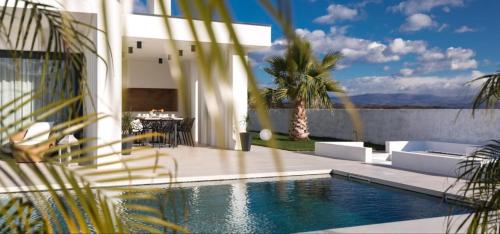 a house with a swimming pool next to a building at Luxury Villa Milly Heated indoor and outdoor pool in Vrh