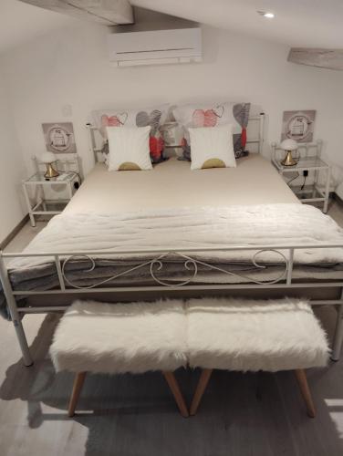 un lit avec des draps blancs et des oreillers dans une chambre dans l'établissement Maison chez Marthe, au Muy