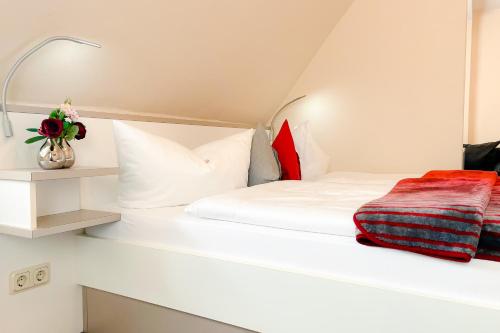 a bedroom with a white bed with red pillows at Altstadt-Hotel in Freiberg