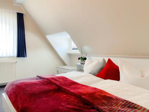 a bedroom with a white bed with red pillows at Altstadt-Hotel in Freiberg