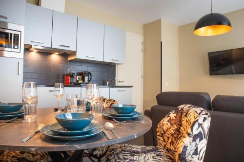 a table with plates and glasses on it in a kitchen at Golden Mansion Apartment Hotel in Amsterdam