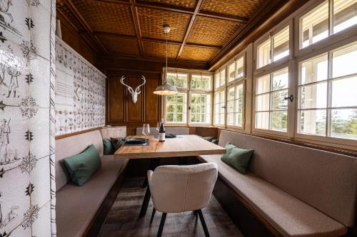 a dining room with a table and chairs and windows at Sonnenhäusle - Natur. Fernblick. Panorama-Sauna. in Sasbachwalden