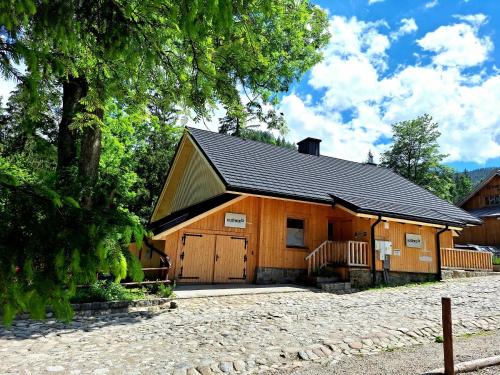 a large wooden building with a garage at Apartamenty Kuźnice 13 in Zakopane