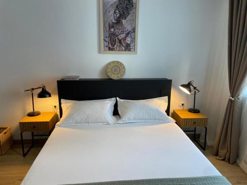クラヨーヴァにあるDecebal-Residence High View Apartmentの大きな白いベッドと2つのランプのある寝室