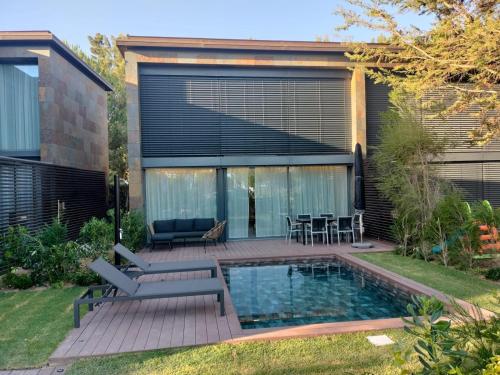 a backyard with a swimming pool and a house at Moradia Prime em Tróia com Piscina Privada in Troia