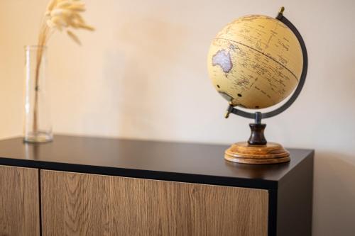 a globe on top of a cabinet with a vase at Sonnenhäusle - Natur. Fernblick. Panorama-Sauna. in Sasbachwalden