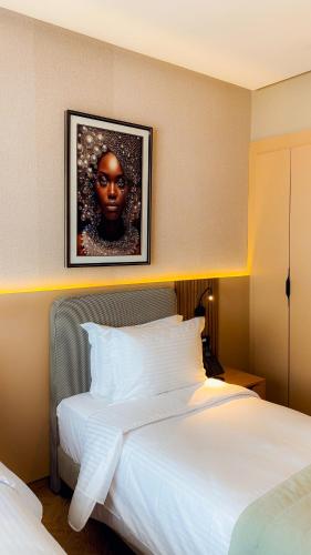 a bedroom with a bed with a picture of a black woman at Elite View Hotel Dakhla in Dakhla