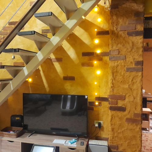 a living room with a large tv and a yellow wall at 兔窩很Chill in Yilan City