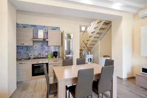a kitchen and dining room with a wooden table and chairs at Casa Alle Porte Della Costiera in Cava deʼ Tirreni