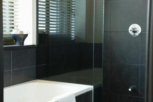 a bathroom with a shower with a glass door at Hôtel Le Germain Québec in Quebec City