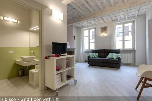 un soggiorno con TV e divano di Vertical Garden Apartments by Mamo Florence a Firenze