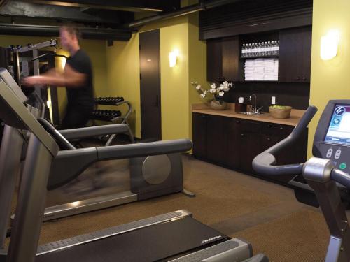 a man running on a treadmill in a gym at Hôtel Le Germain Québec in Quebec City