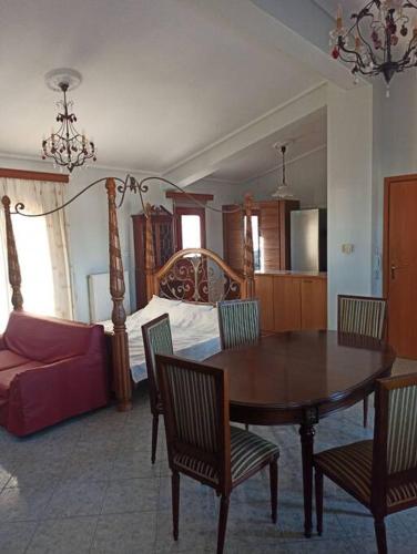 a living room with a dining room table and a bed at Nea Peramos Apartment-2 in Néa Péramos