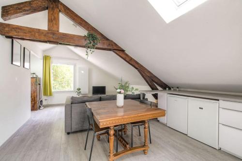 une cuisine et un salon avec une table et un canapé dans l'établissement Loft charmant dans maison de ville, Villeurbanne, à Villeurbanne