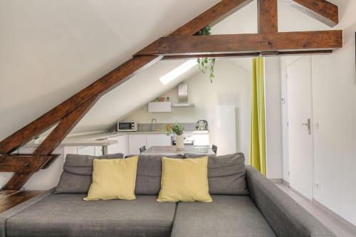 - un salon avec un canapé gris et des oreillers jaunes dans l'établissement Loft charmant dans maison de ville, Villeurbanne, à Villeurbanne