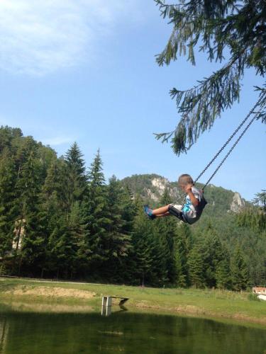 a boy on a rope swing over a lake at Chata Patúch in Babkov