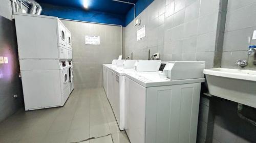 lavadero con electrodomésticos blancos y fregadero en Palermo Soho. 3 ambientes con piscina y cochera, en Buenos Aires