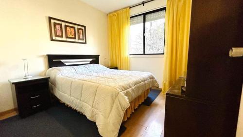 1 dormitorio con 1 cama y una ventana con cortinas amarillas en Palermo Soho. 3 ambientes con piscina y cochera, en Buenos Aires