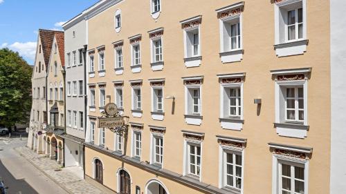 a building with white windows on a street at Ambiance Hotel - Braunau - Simbach in Braunau am Inn