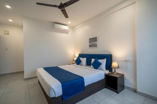 a bedroom with a blue and white bed and a ceiling at Hotel G Skyla Srirampura Malleshwaram in Bengaluru