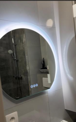 La salle de bains est pourvue d'un miroir rond sur un mur. dans l'établissement Studio Mila, à Nice