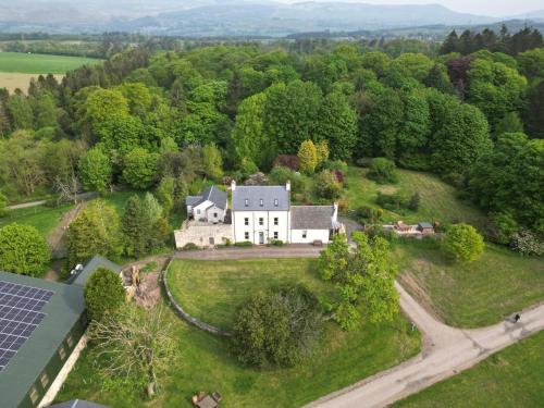 an aerial view of a white house with a solar roof at The Farmhouse at Solsgirth Home Farm in Dollar