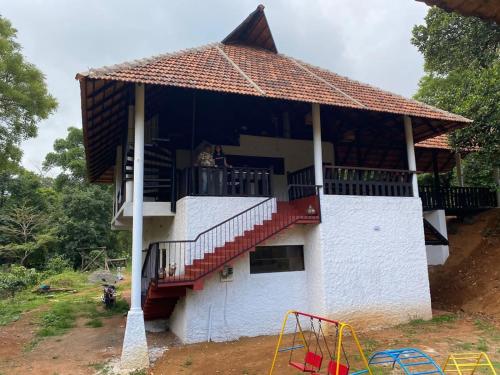 a house with a balcony and a playground at T Stop Estate in Kurchi