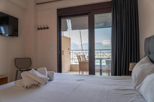 a bedroom with a bed with a view of the ocean at Prego Living Apartments in Vathí