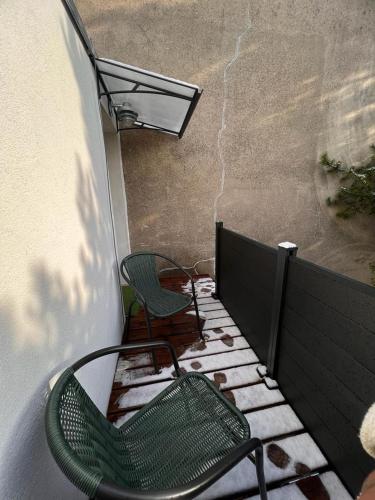 - deux chaises assises sur un balcon avec un bâtiment dans l'établissement Studio avec terrasse, à Colombes