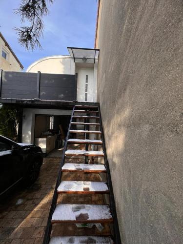 un escalier menant à un bâtiment recouvert de neige dans l'établissement Studio avec terrasse, à Colombes