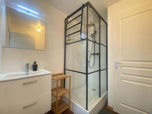 une salle de bain avec une douche en verre et un lavabo dans l'établissement Au bord de mer, à Saint-Benoît-des-Ondes