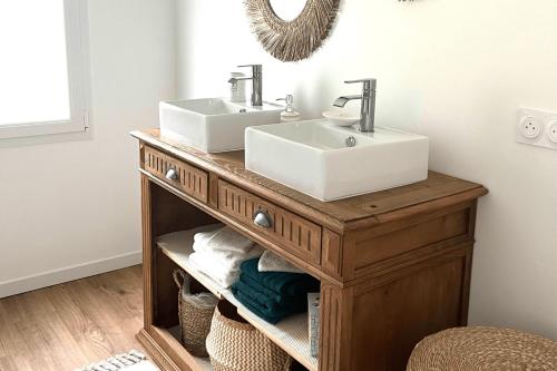 a bathroom with a wooden vanity with two sinks on it at Chez Josie, cottage en Bretagne in Bannalec