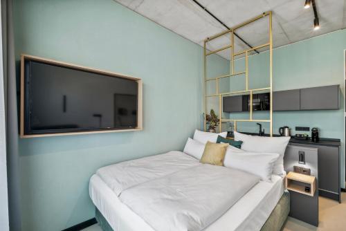 a bedroom with a large bed with a flat screen tv at Nena Apartments München City East in Munich