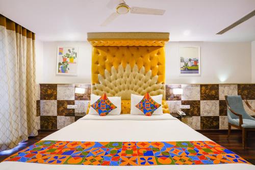 a bedroom with a bed with a yellow headboard at FabHotel WR Grand- Nr Citi Neuro Centre- Banjara Hills in Hyderabad