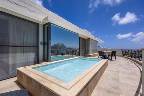a swimming pool on the roof of a house at Mellieha Penthouse with pool and view by Homely in Mellieħa